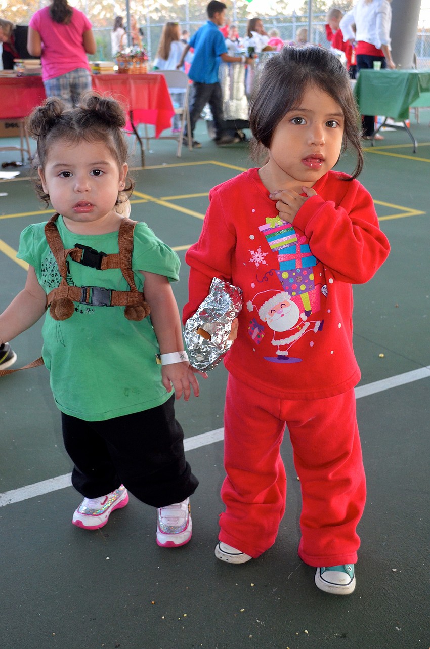 Sisters Erica Hapa, 1, and Genesis, 3, stuff their faces with hot dogs and candy.