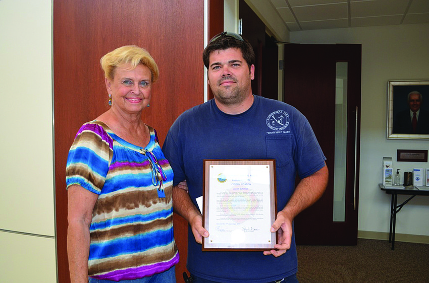 Public Works employee Jason Schmidt, with his grandmother, Jan Schmidt, receives a citizen citation certificate at the Longboat Key Town Commission's April 15 workshop for helping to escort three people out of a fire at a Land's End home March 21.