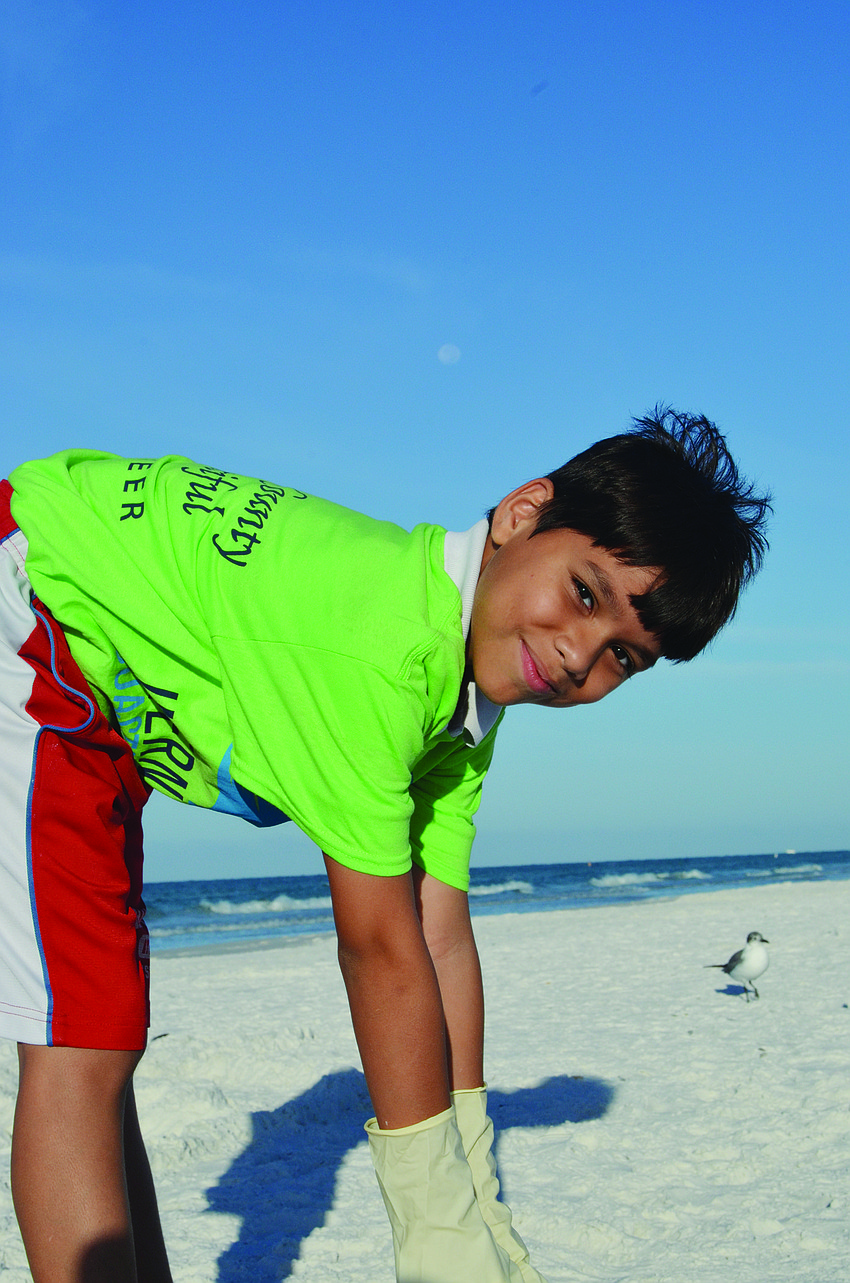 Anthony Gutierrez, 10, picks up trash Sept. 21 during Keep Sarasota County Beautiful's participation in International Coastal Cleanup Day. About 2,400 people in Sarasota County volunteered to clean up their community.