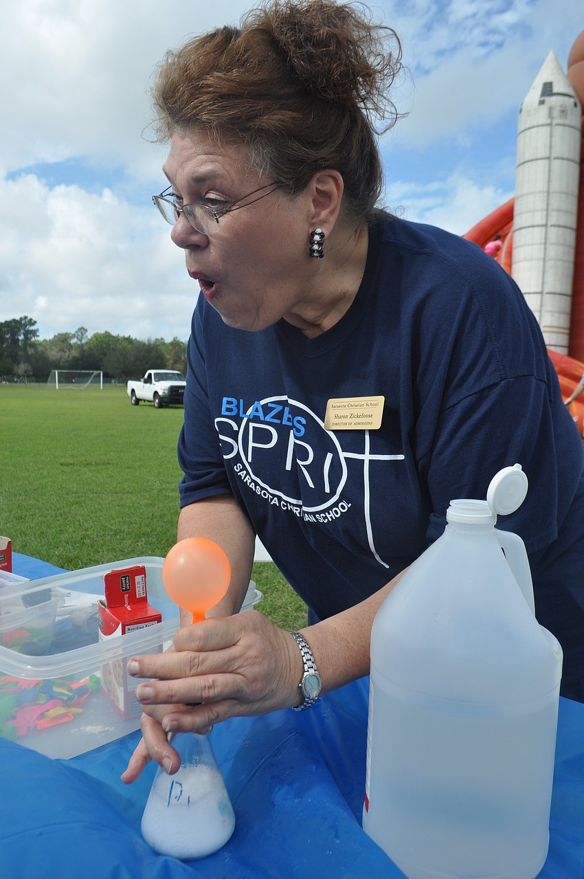 Sarasota Christian Schoolâ€™s Sharon Zickefoose shows children how to blow up a balloon by mixing vinegar and baking soda to create carbon dioxide.