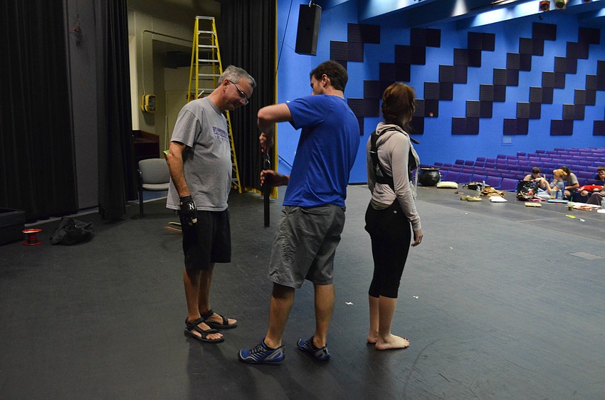 Flying expert John Moore (blue) teaches technical director Mike Beaumier how to properly hookup his daughter Gretchen Beaumier to the flying apparatus