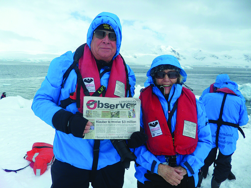 COLD SNAP. Robert Schuler and his wife, Eileen, brave the cold to read their Longboat Observer at Neko Harbour in Antarctica.