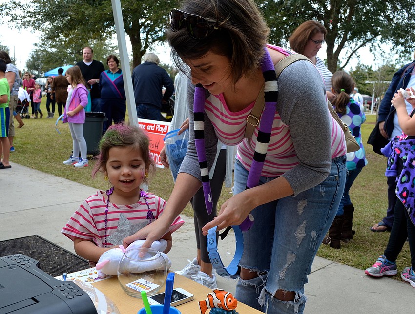 Laiyla Niski, 3, and her mother, Breanca, gather raffle tickets to play games.