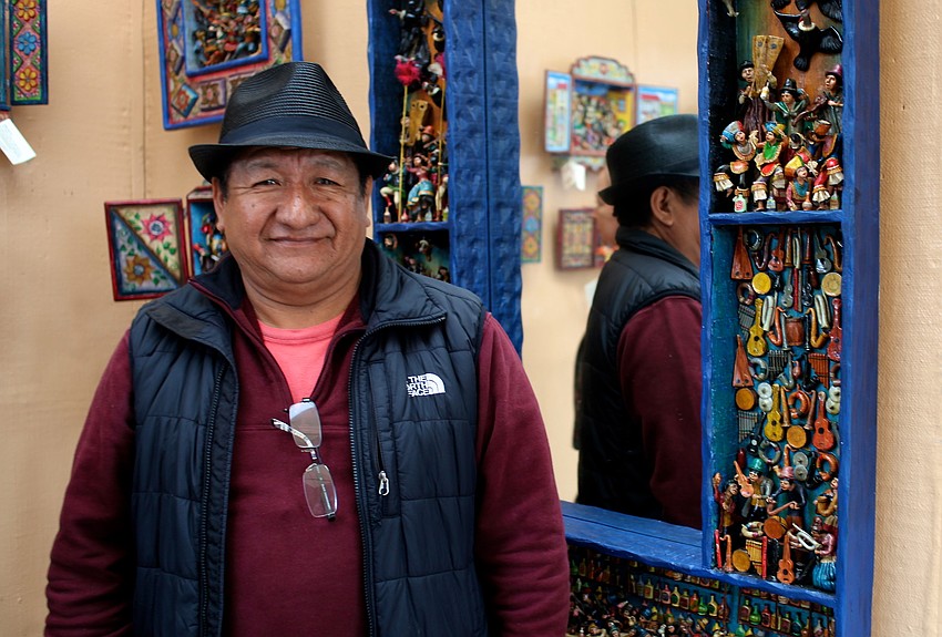 Nicario Jimenez features unique retablos, which are portable wooden boxes filled with brightly colored figurines arranged in narrative scenes, in his booth.
