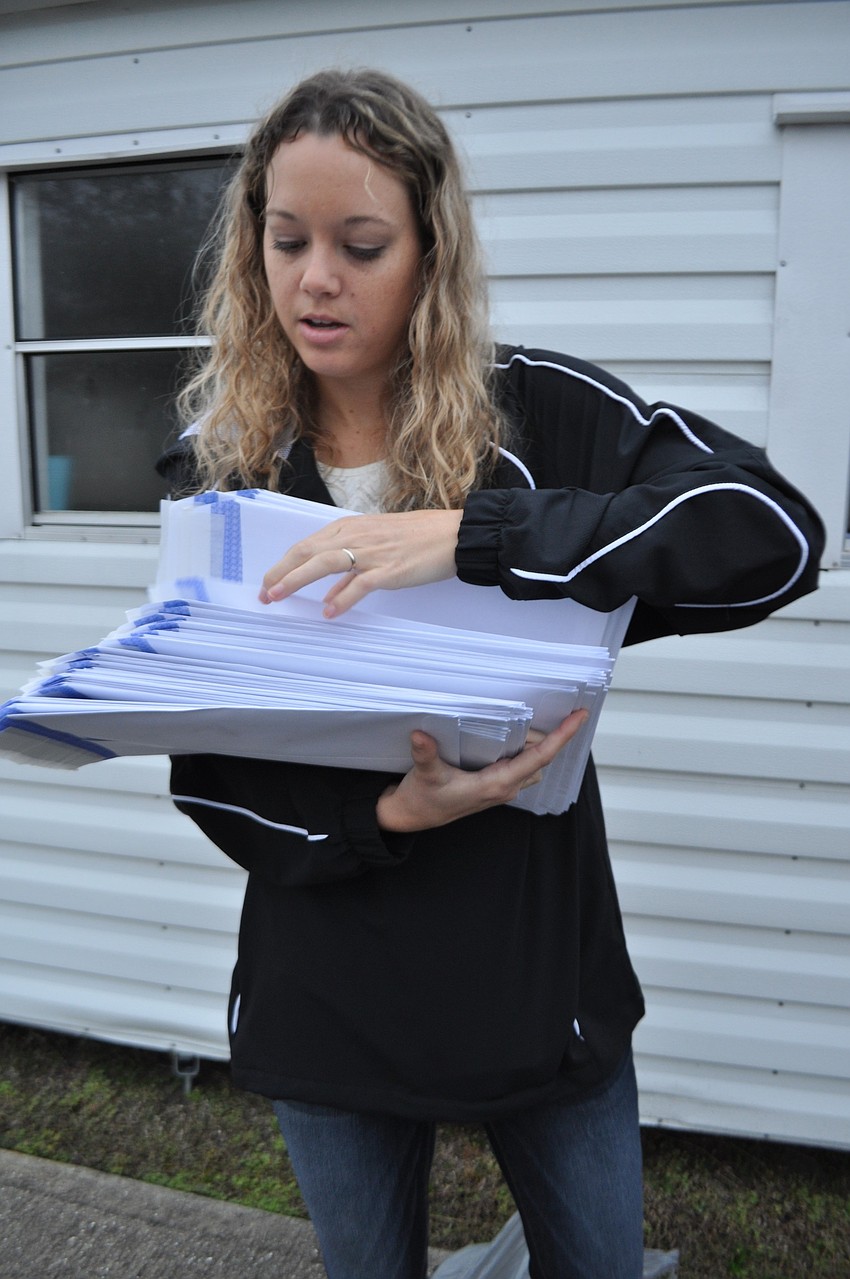 Jackie Gehndyu, the coach's wife, distributes registration packets.