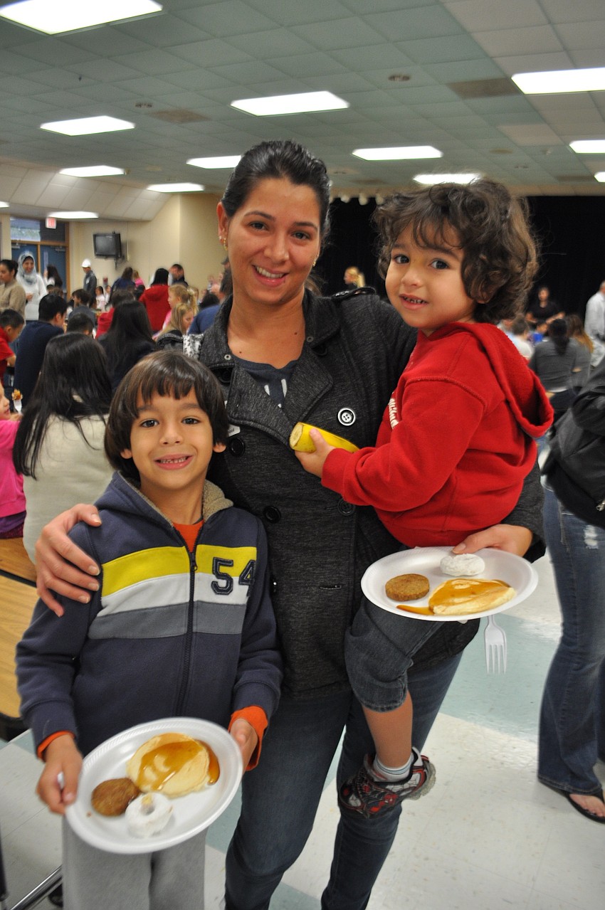 Christopher, Luciana and Matthew Silva prepare to eat.