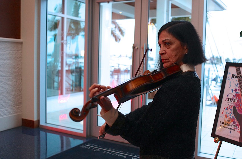 Laurie Vodnoy-Wright plays violin during cocktails.