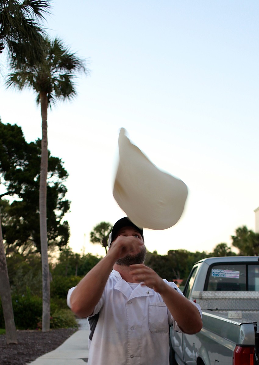 Bert Taylor tosses the dough by the food truck.