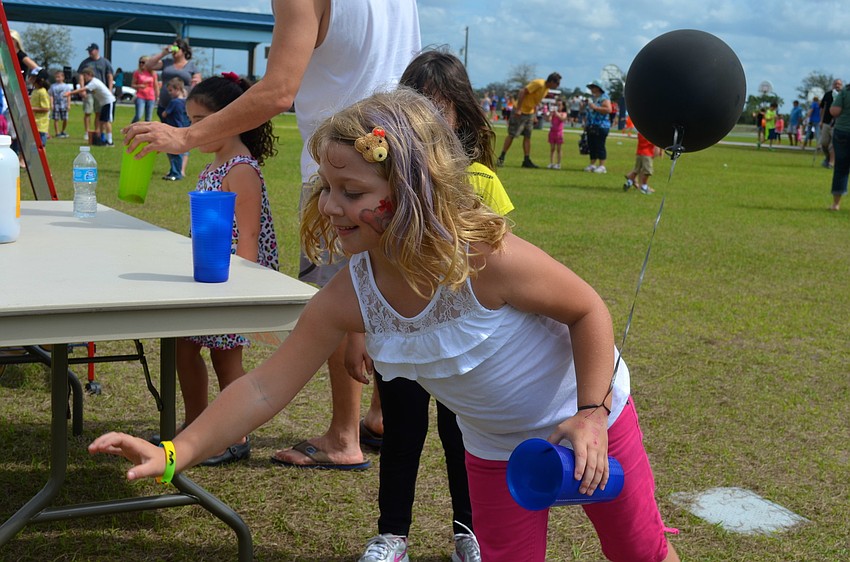 Kalli Bryan, 6, throws ping-pong balls for a prize.