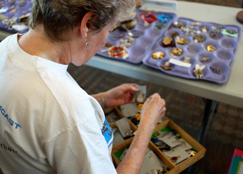Linda Wilson unpacks and organizes necklaces, bracelets and earrings.