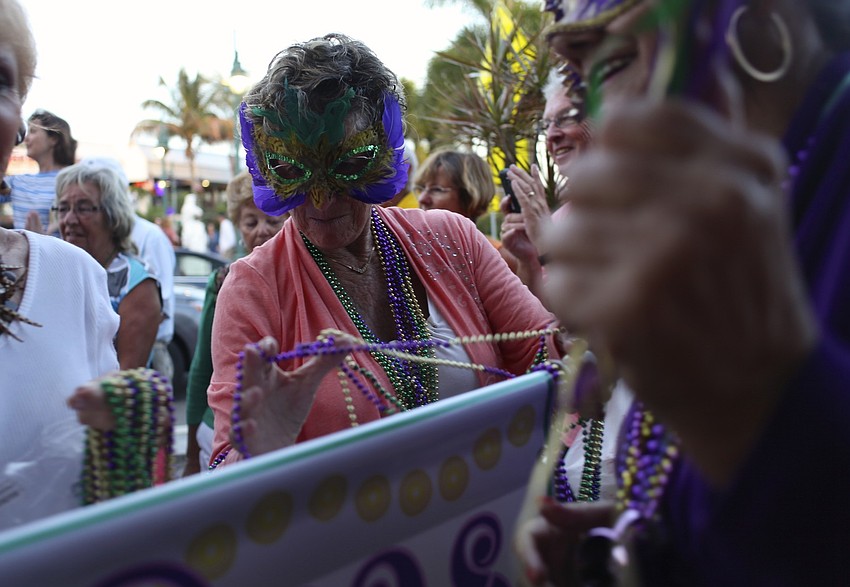 Joyce Ryan leads the parade while throwing beads to the crowd.