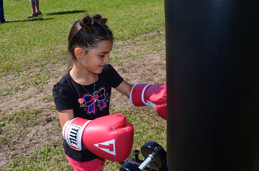 Mya Sua, 6, shows off her strength, while hitting a Title Boxing Club punching bag.