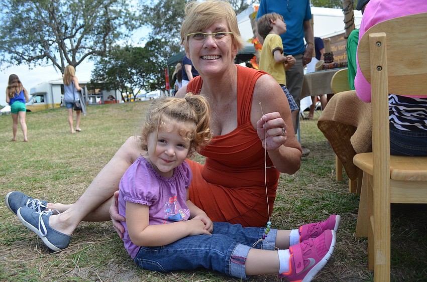 Annie Arnow and nanny, Karen Landry, make a bracelet.