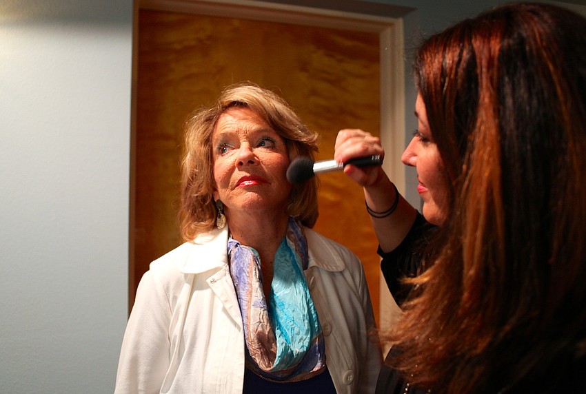 Joan Partridge gets her makeup done by Geri Riley in the dressing room.