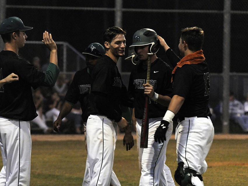 Lakewood Ranchâ€™s Justin Fischer is congratulated by his teammates after scoring the game tying run in the top of the third inning.
