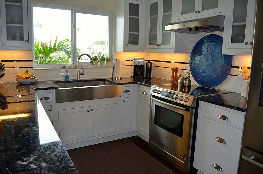 The kitchen was remodeled with black granite countertops.