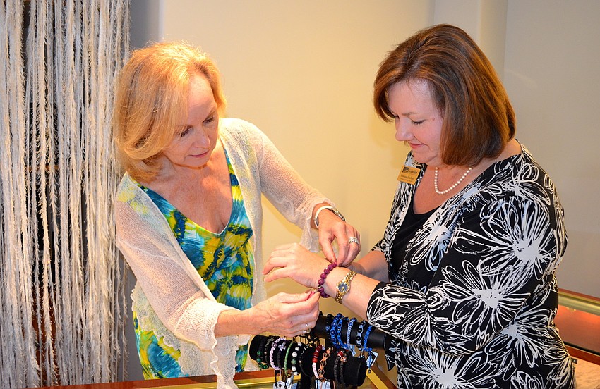Joan Danick shows Morgan Gerhart a few featured bracelets at the boutique.