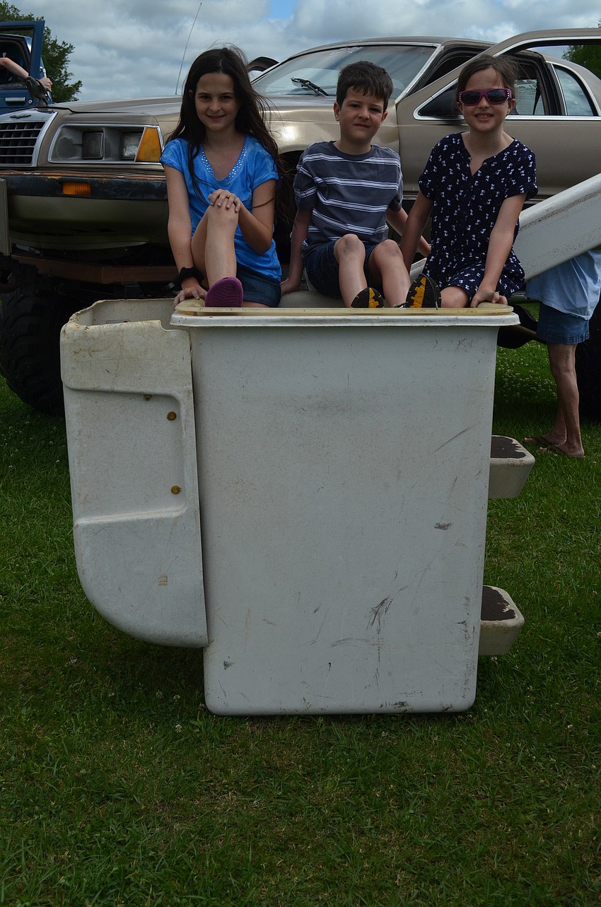 Erin, Sean and Samantha Collins sit in a cherry picker.