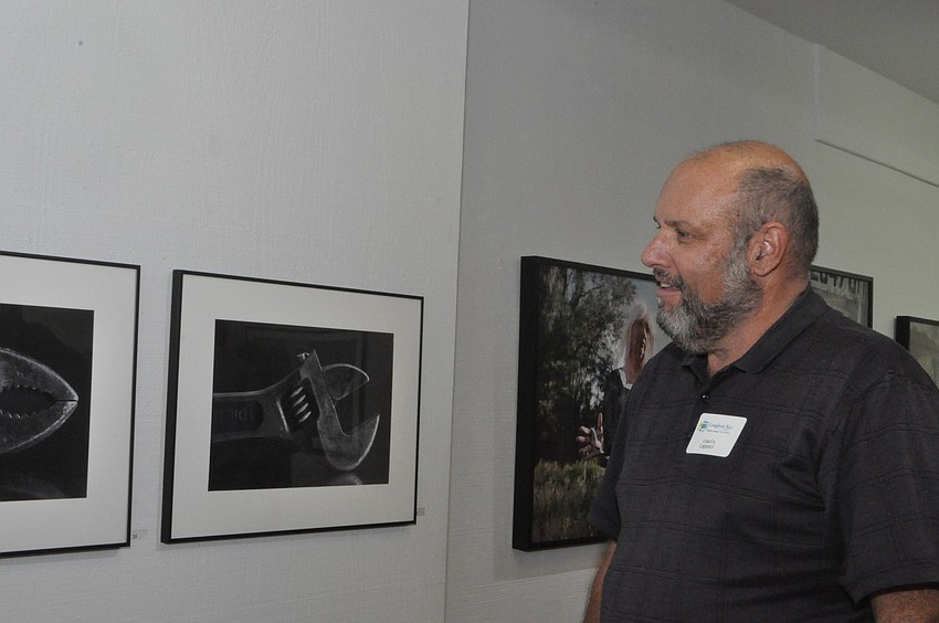 Louis Caponi admires Ken Strothmanâ€™s tool photographs.