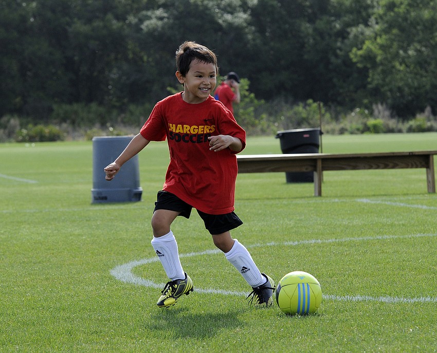 Five-year-old Charlie Mennes practices his dribbling before the start of his teamâ€™s game.