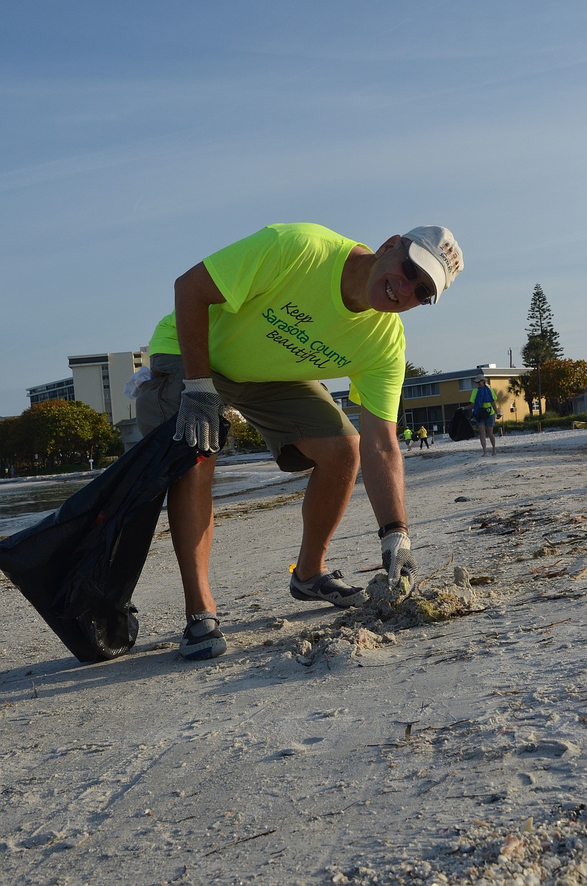 Bill Irish cleans the beach.
