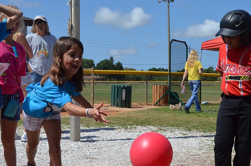 Bella Knapp plays a bowling game at one of the game booths students set up.