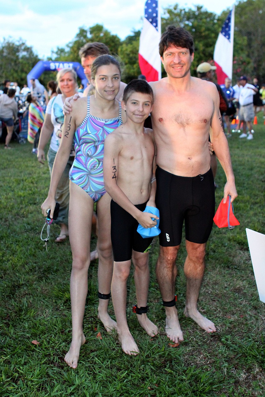 Lillie Marcos, 12, JP Marcos, 12, and Matt Marcos of New York, tried to stay warm before starting the Longboat Key Sprint Triathlon.