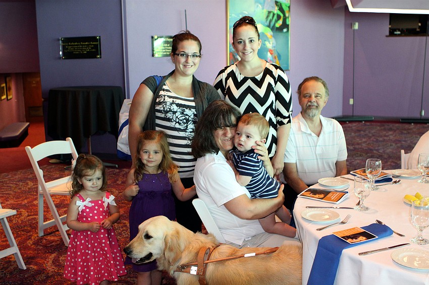 Rhonda Partain, seated in center, with her new guide dog Caesar and her family who all came in from Rockmart, Georgia for the graduation ceremony.