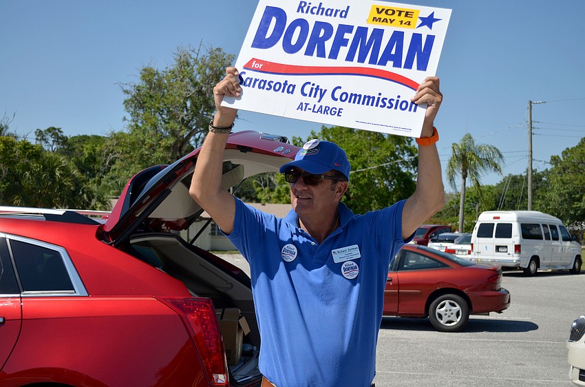 Richard Dorfman waves his campaign sign to passersby.
