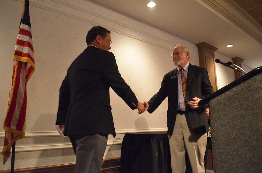 Veteran and award recipient Steve Wilberding shakes Board Chair of Jewish Family and Children Services Rich Segallâ€™s hand and accepts his award.