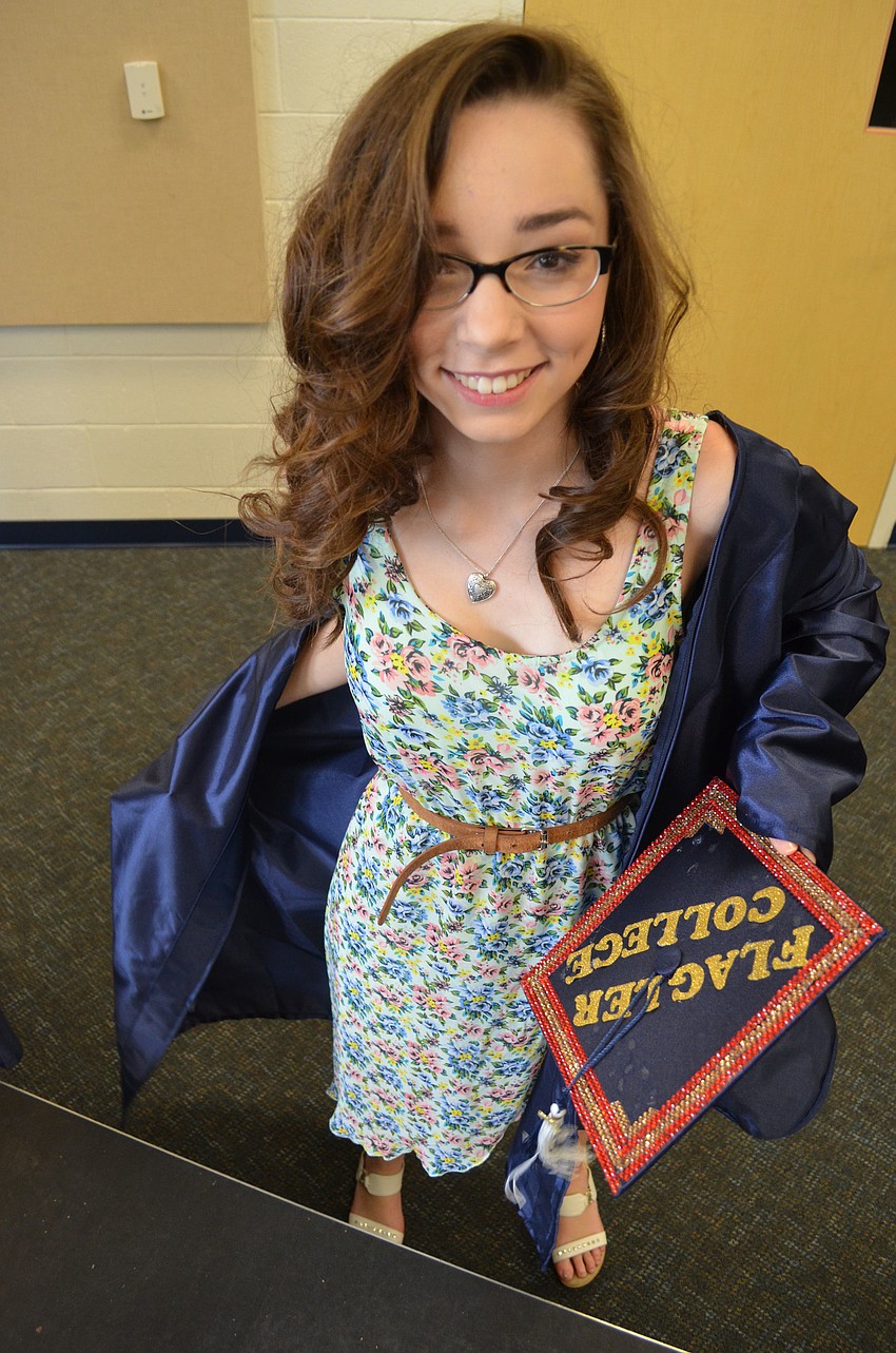 Stephanie Muench puts on her cap and gown. She will attend Flagler College in the fall, where she will major in English and business, with a minor in creative writing.