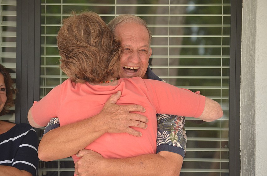 Skip Huene hugs his wife Glendy during the surprise renaming of the library.