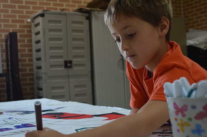 Matthew Harriman, 6, colors his mask.