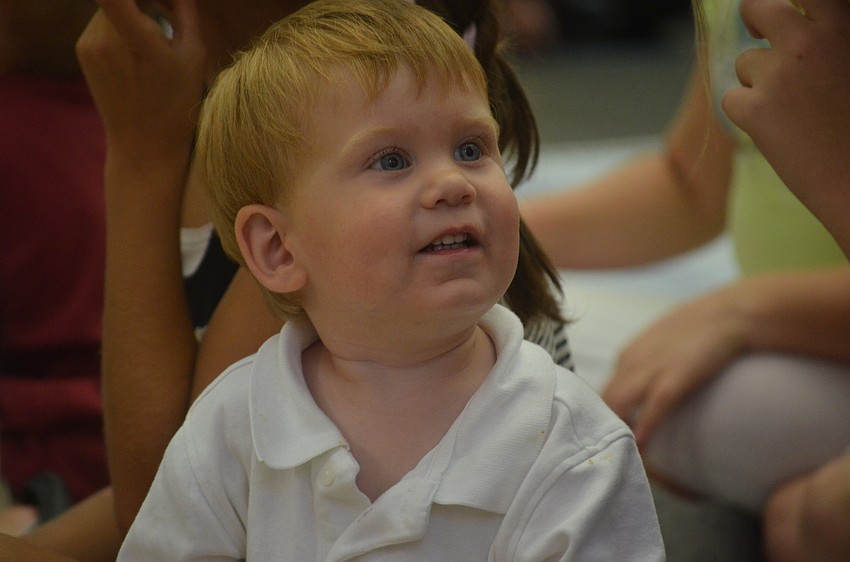 Asher Wycoff, 21 months, watches the magic show happily.