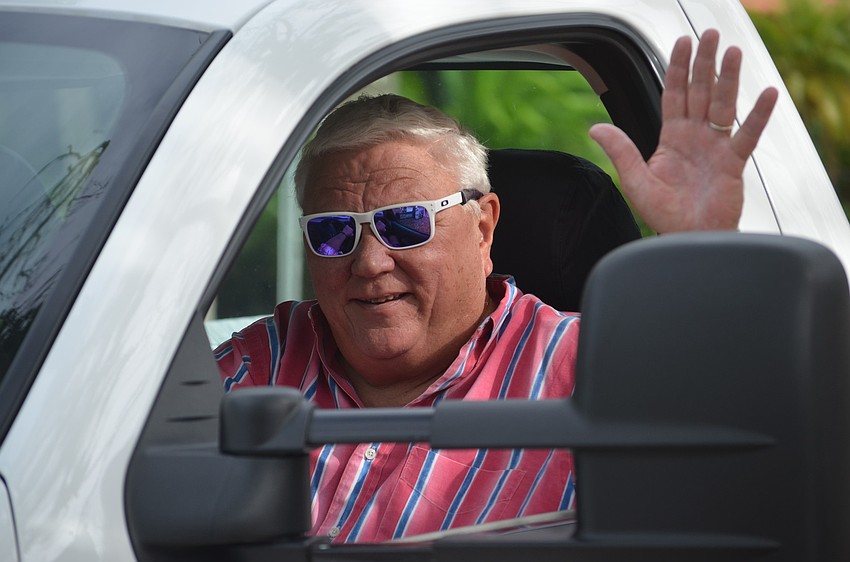 Cannons Marina Owner David Miller waves to the crowd as he passes them in the parade.
