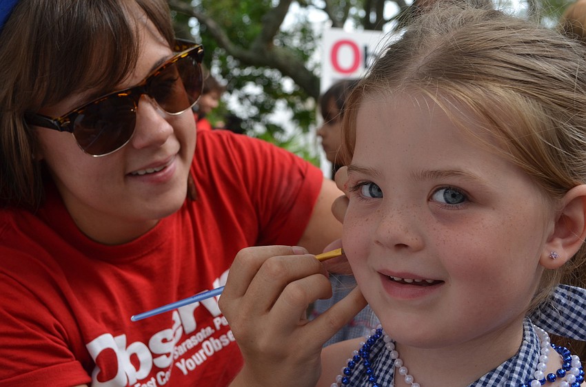 Mallory Gnaegy paints four-year-old Natalie Rayâ€™s face.