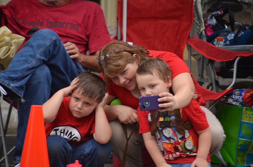 Zachary Freeman doesnâ€™t like the cars honking and his mother Jennifer tries to get a photograph with him and his brother Matthew.