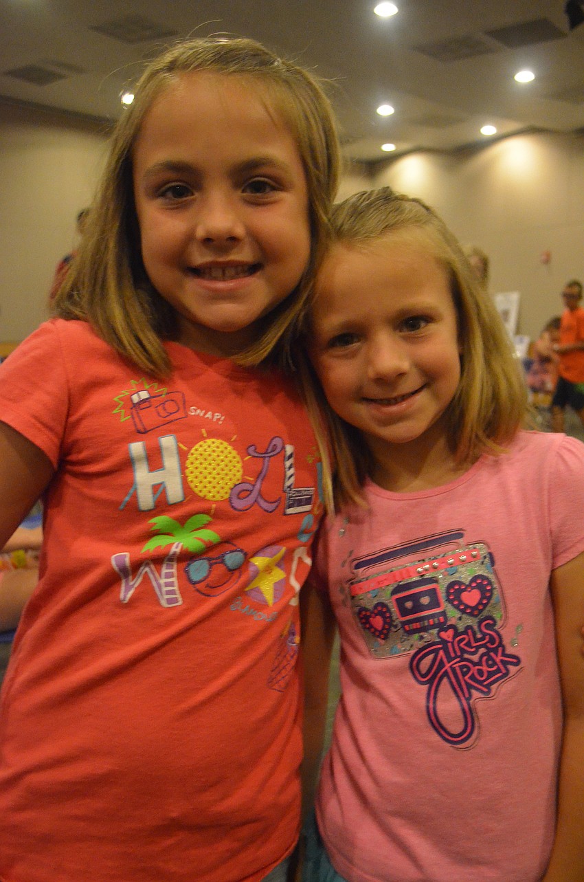 Olivia Kolb, 8, and her sister Ella, 6, listen to the story â€œNoah and the Search Dogs.â€
