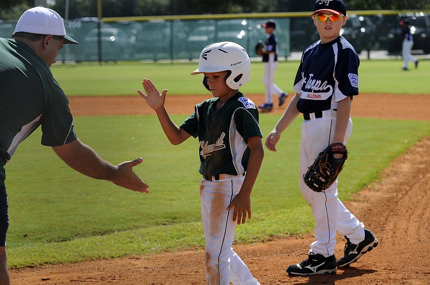 Connor Shine receives congratulations from one of his coaches after hitting an RBI single in the first inning.