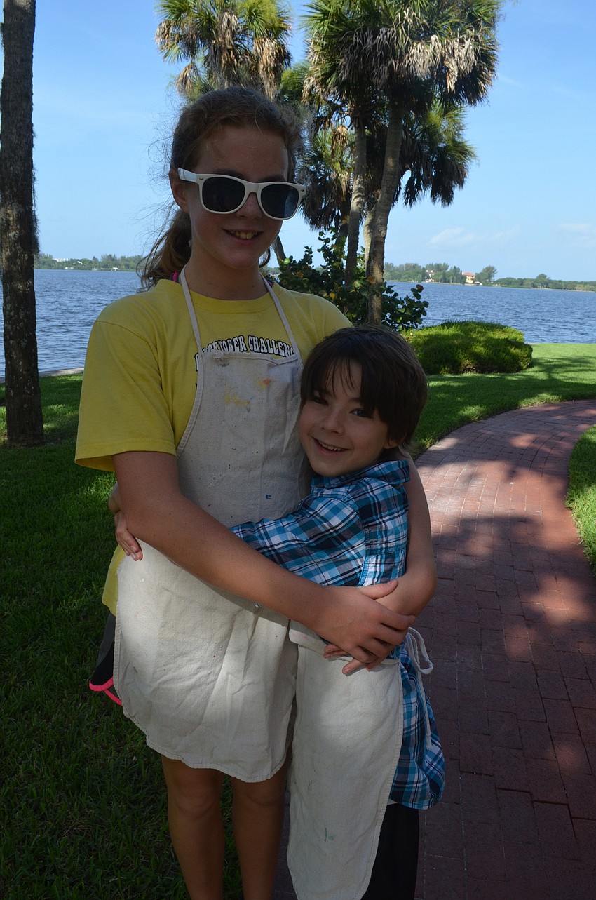 Graham Shelton, 8, gives his sister Emma, 12, a hug before starting his printmaking project.