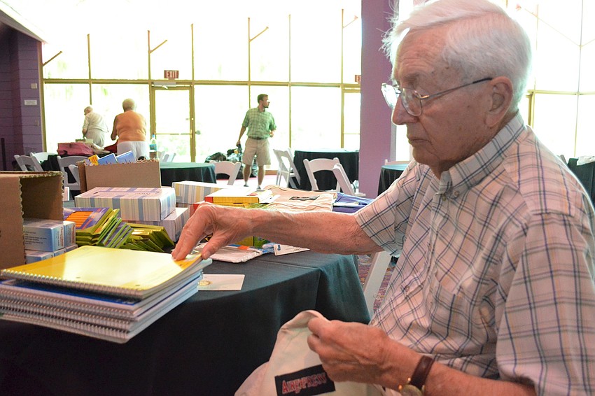 Wendell Kent fills backpacks full of school supplies.
