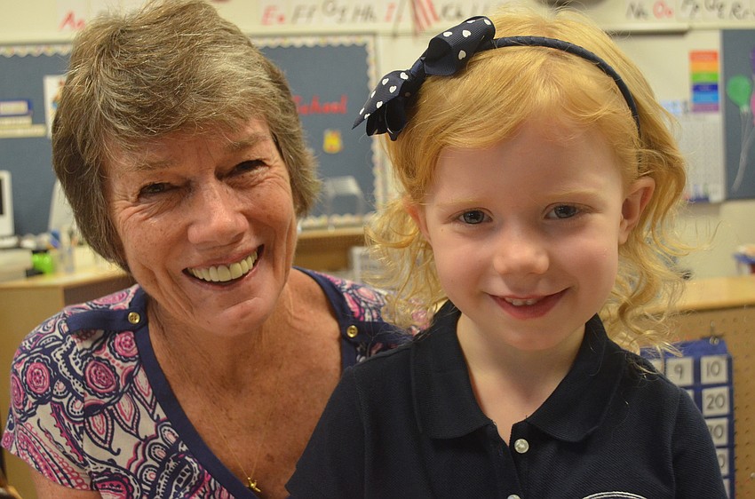 Caitlin A. shows her new kindergarten teacher Jane Hancock a picture she drew on her first day of school.