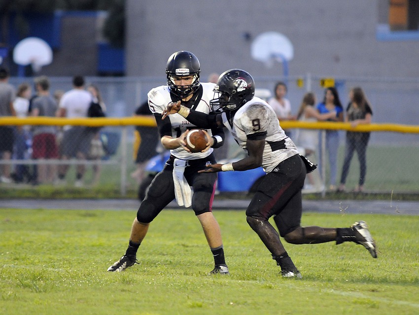 Braden River quarterback Dusty Peebles hands the ball off to running back Titus Humphry.