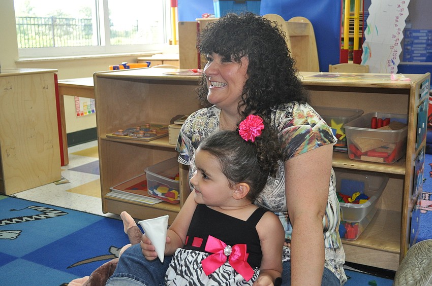 Christine Belville and her daughter, Rylee, 3, listened to a reading of Curious George.