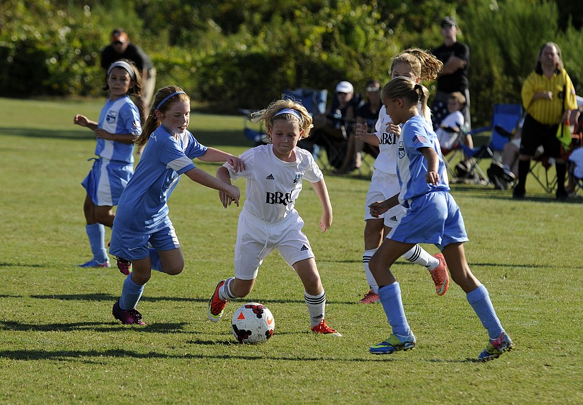 Ten-year-old Peyton Massie attempts to maneuver the ball past a pair of FC Florida defenders.