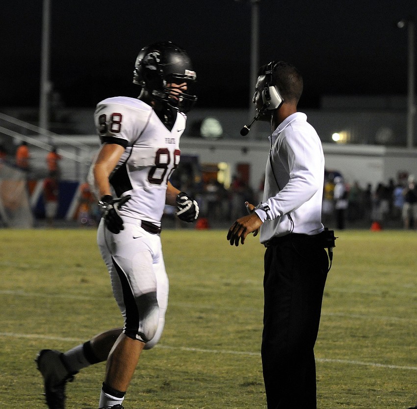 Braden River coach Curt Bradley congratulates defensive end Derek Hintze after the Pirates forced Southeast to punt the football.