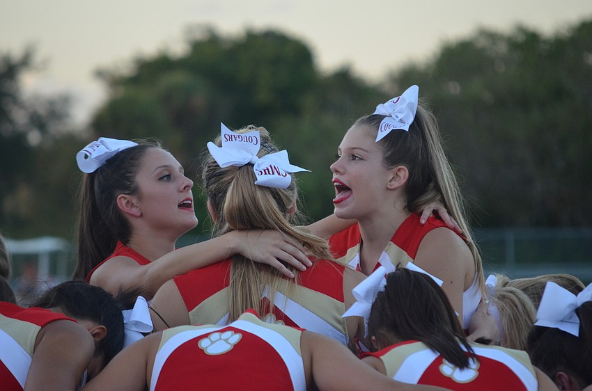 Cheer captain Summer Egly, 17, and co captain Savannah Savadel, 17, cheer for their team as they prepare to be lifted.