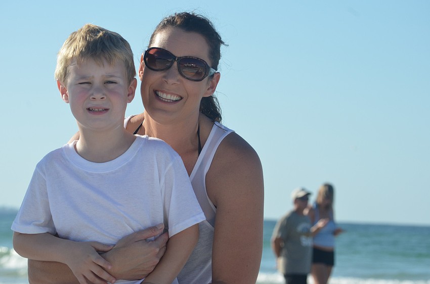 Logan Neufeld and his mother Kim are excited to get in the water at the Hang Ten for Autism Surfing Event.