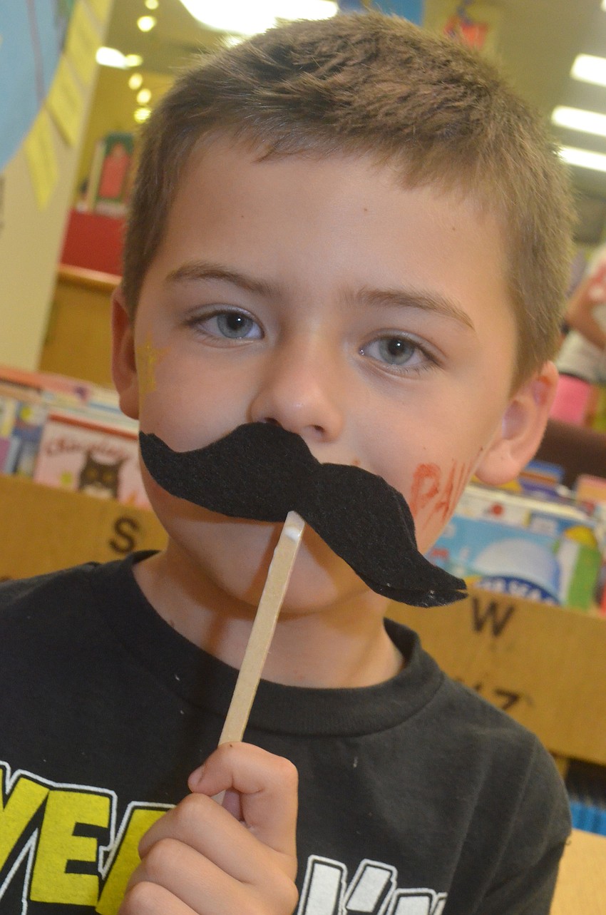 Paul Beecher, 6, shows off his mustache craft.