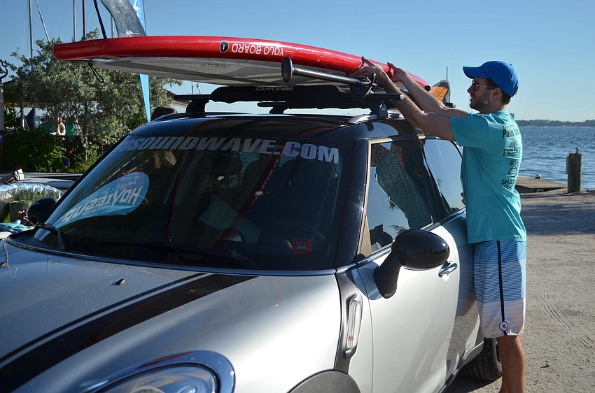 Matt Kearney unloads his paddleboard in front of Sarasota Sailing Squadron.